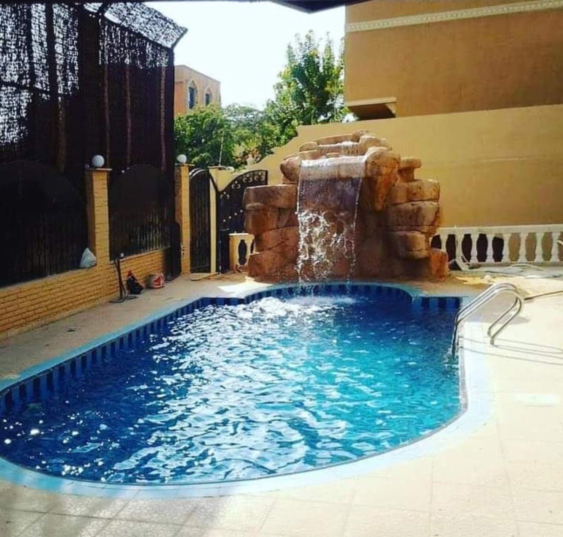 MKG Group fiberglass rock waterfall feature beside a swimming pool