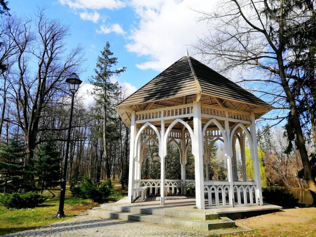 Sample gazebo design: white park gazebo with a pitched roof and arched openings