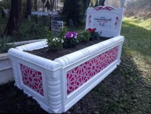 Decorative white fiberglass grave structure with pink patterned panels
